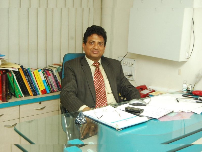 Dr. V.S. Pal, a leading psychiatrist in Indore, sitting in his office surrounded by medical books and professional equipment.
